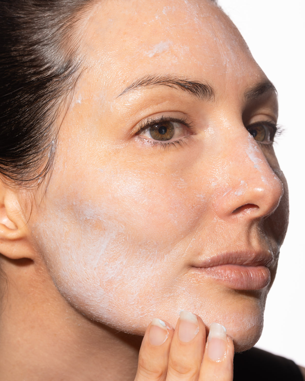 Close up on woman's face cleansing with The Reset